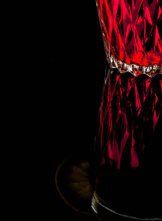 A glass with red drink on a dark background.の写真素材