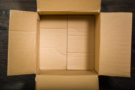 open square cardboard box on the background of the old wooden table. View from above. Space for text.の写真素材