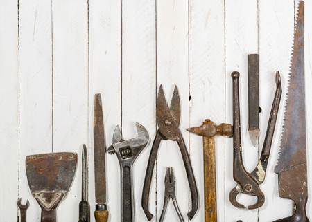 Many old rusty tools scattered on the wooden tstolu. View from above. Space for text.の写真素材