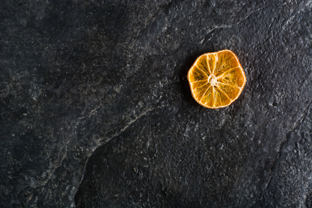 Dry slices of citrus fruits on a black slate background. Space for text.の写真素材