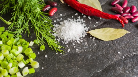 Arrangement of chives, onions, beans and dill on a black background stone slate. View from above.の写真素材