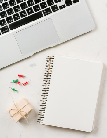 Business background with laptop and notepad on white stone background. Empty page.の写真素材