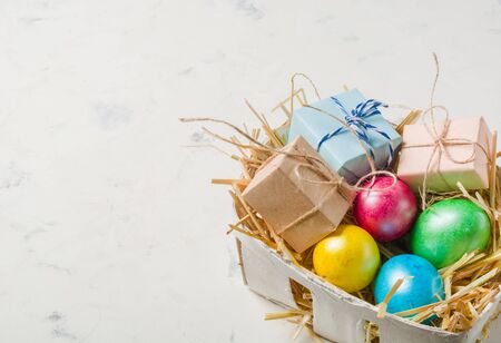 Easter background with multi-colored chicken eggs on a white stone slab. Place for the text.の写真素材
