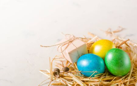 Easter background with multi-colored chicken eggs on a white stone slab. Place for the text.の写真素材