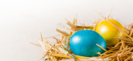 Easter background with multi-colored chicken eggs on a white stone slab. Place for the text.の写真素材