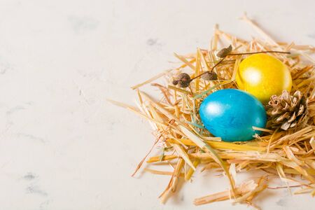 Easter background with multi-colored chicken eggs on a white stone slab. Place for the text.の写真素材