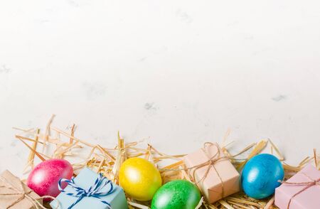 Easter background with multi-colored chicken eggs on a white stone slab. Place for the text.の写真素材