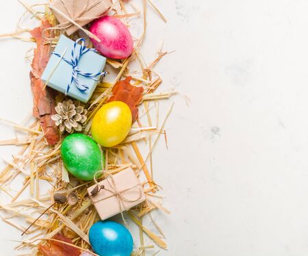 Easter background with multi-colored chicken eggs on a white stone slab. Place for the text.の写真素材