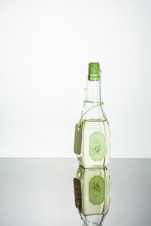 Vegetable oil in a bottle on a white wooden background. Place for the text.の写真素材