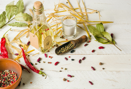 Vegetable oil in a bottle with seasonings and spices on a white wooden background. Place for the text.の写真素材