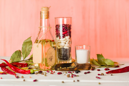 Vegetable oil in a bottle with seasonings and spices on a white wooden background. Place for the text.の写真素材