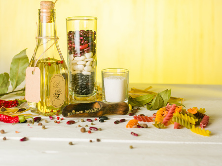 Vegetable oil in a bottle with seasonings and spices on a white wooden background. Place for the text.の写真素材