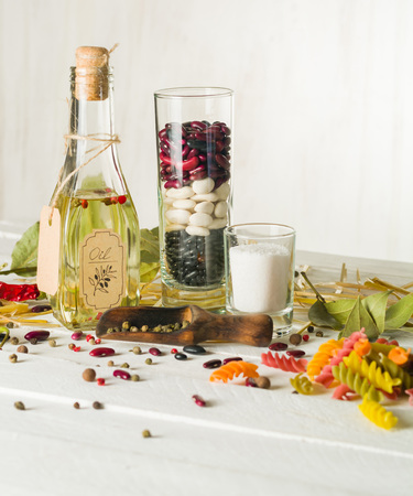Vegetable oil in a bottle with seasonings and spices on a white wooden background. Place for the text.の写真素材