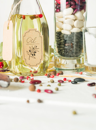 Vegetable oil in a bottle with seasonings and spices on a white wooden background. Place for the text.の写真素材