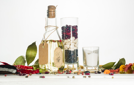 Vegetable oil in a bottle with seasonings and spices on a white wooden background. Place for the text.の写真素材