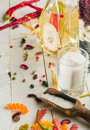 Vegetable oil in a bottle with seasonings and spices on a white wooden background. Place for the text.の写真素材