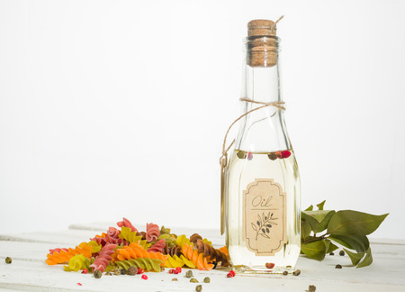Vegetable oil in a bottle with seasonings and spices on a white wooden background. Place for the text.の写真素材