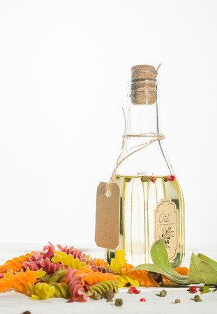 Vegetable oil in a bottle with seasonings and spices on a white wooden background. Place for the text.の写真素材