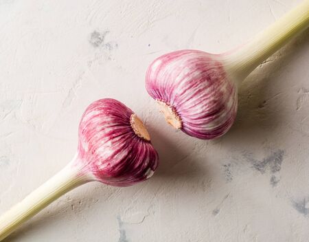 Garlic purple stalk on a white stone background. A lot of empty space.の写真素材