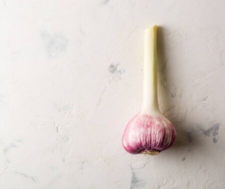 Garlic purple stalk on a white stone background. A lot of empty space.の写真素材