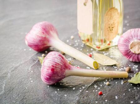 Garlic purple with stem on a black stone background. A lot of empty space.の写真素材