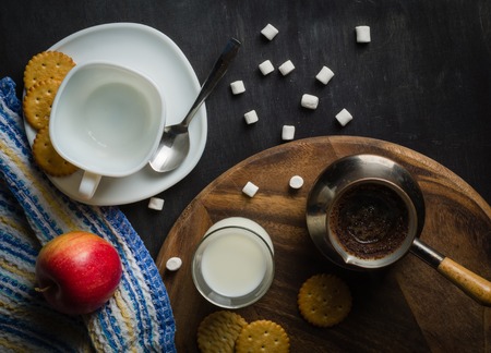 Morning coffee with marshmallows, cookies and milk. Dark wooden background. Place for the text.の写真素材