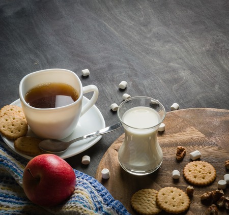 Morning coffee with marshmallows, cookies and milk. Dark wooden background. Place for the text.の写真素材