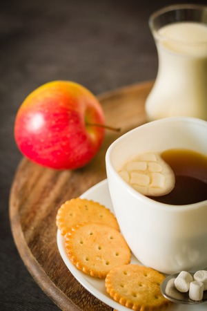 Morning coffee with marshmallows, cookies and milk. Dark wooden background. Place for the text.の写真素材