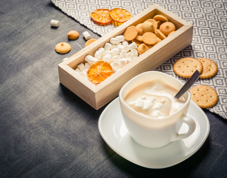 Morning cocoa with marshmallows, cookies and milk in wooden box. Dark wooden background. Place for the text.の写真素材
