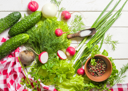Variety of vegetables on a white wooden table together with a red checkered cloth. View from above.の写真素材
