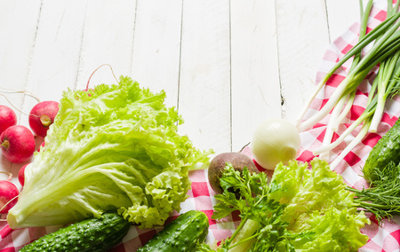 Variety of vegetables on a white wooden table together with a red checkered cloth. View from above.の写真素材