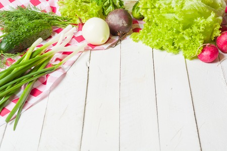 Variety of vegetables on a white wooden table together with a red checkered cloth. View from above.の写真素材