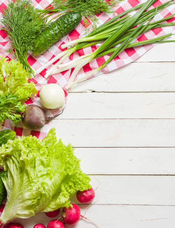 Variety of vegetables on a white wooden table together with a red checkered cloth. View from above.の写真素材