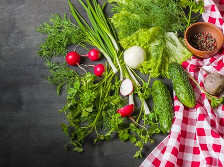 Variety of vegetables on a black wooden table with a red checkered cloth. View from above.の写真素材