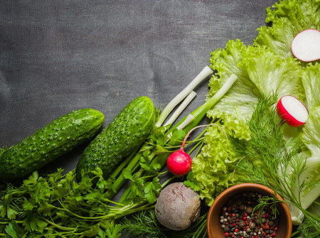 Variety of vegetables on a black wooden table. Spring still life. View from above.の写真素材