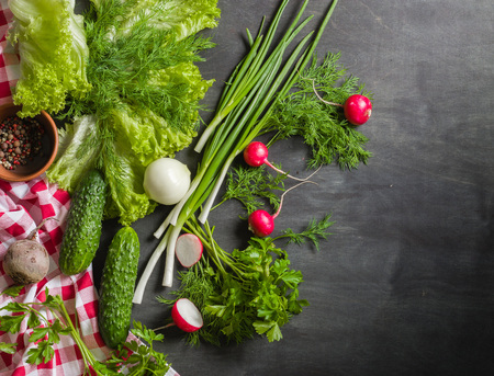 Variety of vegetables on a black wooden table with a red checkered cloth. View from above.の写真素材