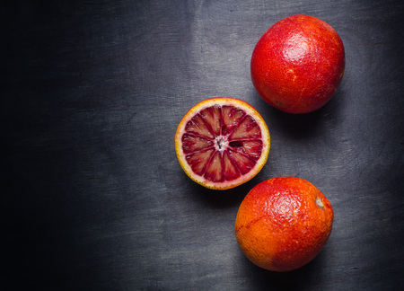 Several oranges of orange and red on a black background. View from above. Minimalistic design.の写真素材
