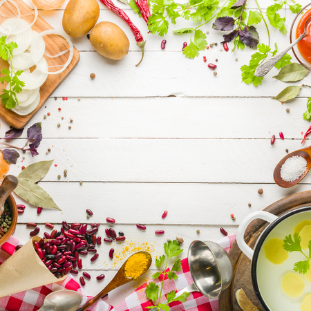 Preparation of soup at home. Rustic white background with vegetables and ingredients around the perimeter.の写真素材