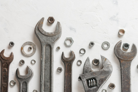 A lot of old wrenchs on a light stone background. Nuts and washers of different sizes.の写真素材