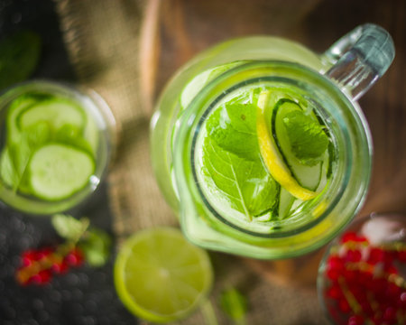 Water detox in a glass jar and a glass. Fresh green mint and berries. A refreshing and healthy drink. Copy space.の写真素材