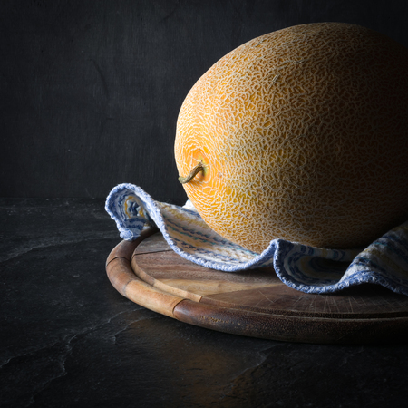 Ripe yellow melon on a dark background. Low key.の写真素材