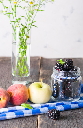 Blackberry and fruit on an old wooden table. Blue textiles. Copy space.の写真素材