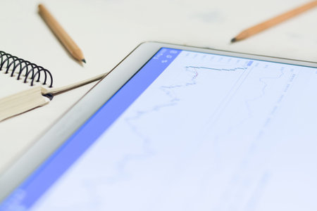 Luminous screen device with charts and quotations of the stock exchange. Finances and stock exchanges. Growth and fall of the rate. Small depth of field.の写真素材