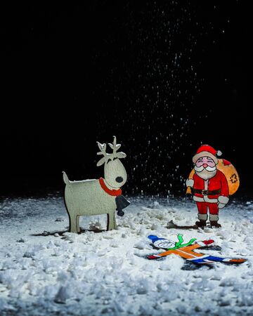 Paper figures of the child as a snow angel Santa Claus and deer. Hand made paper figurine. A blank for a postcard. Copy space.の写真素材
