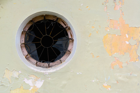 Round old window with a lattice and broken glass. Need repair and restoration.の写真素材
