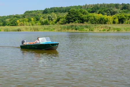 Khororiv, Ukraine - AUGUST 12 2018: A motor boat sailing along the Gulf of the Dnieper River near the village of Khodoriv.のeditorial素材