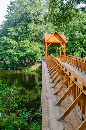 Old wooden bridge over the river with arbor. Forest River.の写真素材