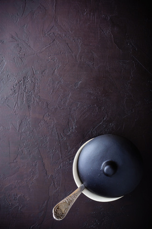 Ceramic or earthenware for soup or mashed potatoes. With a lid and empty without filling. Dark brown background. View from above.の写真素材