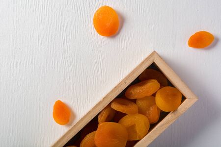 Delicious and healthy dried apricots. Freshly dried. On a white background in wooden box.の写真素材