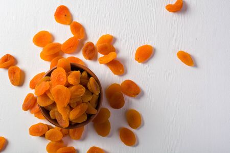 Delicious and healthy dried apricots. Freshly dried. On a white background in wooden bowls.の写真素材